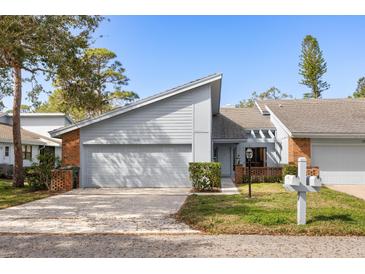 Charming home featuring a two-car garage, light-blue siding, brick accents, and well-manicured landscaping at 2630 Moss Oak Dr # 50, Sarasota, FL 34231