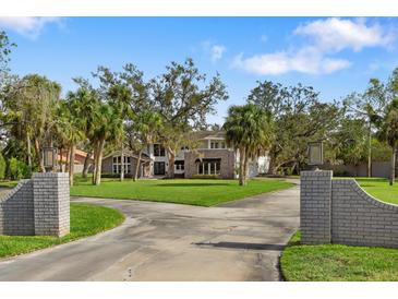 Stately two-story home boasts a brick facade, a sprawling lawn and mature landscaping at 3783 Beneva Oaks Blvd, Sarasota, FL 34238