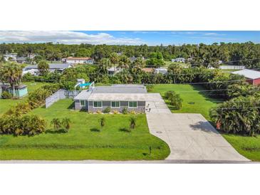 Charming single-story home featuring a well-maintained lawn and long concrete driveway at 8430 Truman St, Englewood, FL 34224
