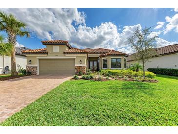 Charming single-story home with a well-manicured lawn, beautiful landscaping, and a tile roof at 16218 Umbria Pl, Bradenton, FL 34211