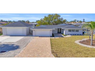 Charming single-story home boasting a paver driveway, separate garage, and freshly landscaped yard at 1950 Fairview Dr, Englewood, FL 34223