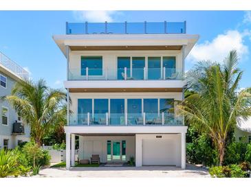 Stunning three-story home with palm trees and multiple balconies at 870 N Shore Dr, Anna Maria, FL 34216