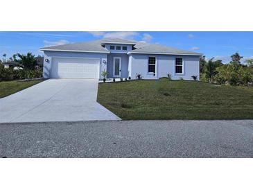 New single-story home with light blue exterior, white garage door, and landscaped lawn at 9245 Zorn St, Port Charlotte, FL 33981