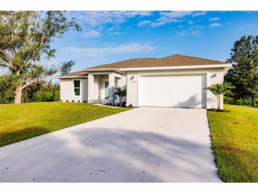 Single-story home with attached garage and landscaped lawn at 1309 Nackman Rd, North Port, FL 34288