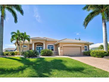 Tan single-Gathering home with palm trees and landscaped yard at 1429 Blue Jay Ct, Punta Gorda, FL 33950