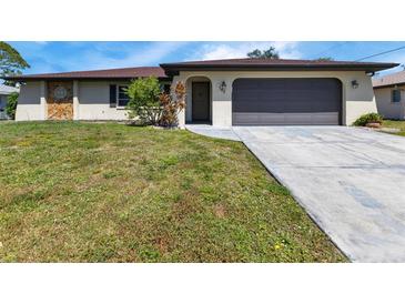 Single-story home with a brown roof, attached garage, and well-maintained lawn at 745 Columbia St, Port Charlotte, FL 33948