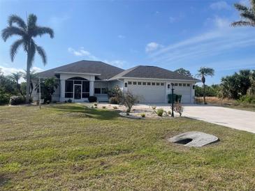 Single-story home with attached garage, landscaping, and a large yard at 18029 Ohara Dr, Port Charlotte, FL 33948