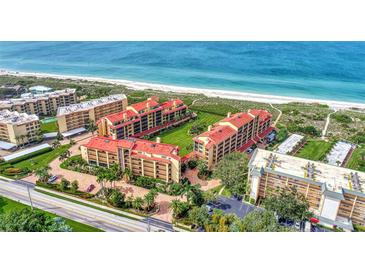 Aerial view of beachfront condos with lush landscaping and ocean views at 8750 Midnight Pass Rd # 202, Sarasota, FL 34242