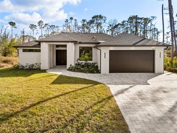 Beautiful single-story home featuring a lush lawn, paved driveway, and modern design at 5823 Kumquat Ave, North Port, FL 34291