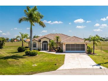 Charming one-story home with a tile roof, large driveway, two-car garage, and meticulously maintained landscaping at 16446 Belo Ct, Punta Gorda, FL 33955