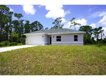 Newly constructed home with a gray exterior, two-car garage, and grassy yard at 2163 Blaser St, Punta Gorda, FL 33980