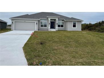 Newly constructed one-story home featuring a gray exterior, two-car garage, and a spacious lawn at 10045 Bay State Dr, Port Charlotte, FL 33981