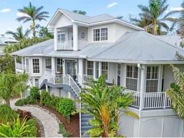 Two story house with gray metal roof, white siding, and lush landscaping at 116 Dolly St, Punta Gorda, FL 33950