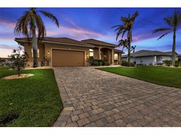 Charming one-story home with lush landscaping, brick driveway and mature palm trees in a waterfront community at 3322 Sandpiper Dr, Punta Gorda, FL 33950