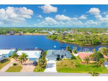 Aerial view of waterfront home with private dock and lush landscaping at 430 Spring Lake Nw Blvd, Port Charlotte, FL 33952