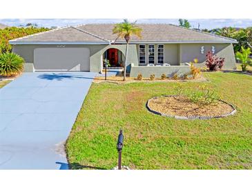 Single-story home with a large driveway and well-manicured lawn at 138 Peckham Sw St, Port Charlotte, FL 33952