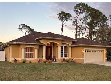 Attractive one-story house with brown roof, tan walls, and a two-car garage at 3100 Sheboygan Ave, North Port, FL 34286