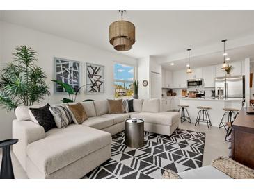 Open living area with L-shaped sofa, stylish rug, and kitchen views at 43981 Boardwalk Loop # 2218, Punta Gorda, FL 33982