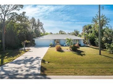 Single story home with light paint, landscaping, and driveway at 18565 Edgewater Dr, Port Charlotte, FL 33948