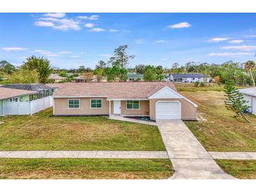 Single-story home with a white garage door and well-maintained lawn at 3324 Avanti Cir, North Port, FL 34287