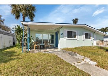 Charming light green house with covered porch and landscaped lawn at 3999 Conway Blvd, Port Charlotte, FL 33952