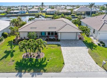 Aerial view of a waterfront home with a large backyard and paved driveway at 2199 El Cerito Ct, Punta Gorda, FL 33950