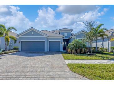 Two-story house with gray siding, double garage, and landscaping at 25223 Keygrass Ct, Punta Gorda, FL 33955