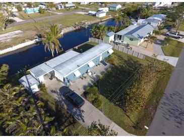 Aerial view of waterfront property with canal access and lush landscaping at 4156 Bardot Rd, Port Charlotte, FL 33953