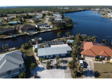 Waterfront home featuring private dock, screened pool, metal roof, lush landscaping and canal access at 193 N Waterway Nw Dr, Port Charlotte, FL 33952