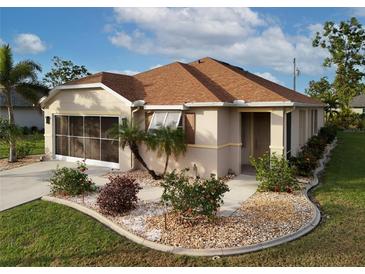 Single-story home with a brown tile roof, landscaped yard, and screened garage at 25554 Prada Dr, Punta Gorda, FL 33955