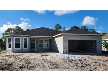 New home features a concrete block exterior, completed roof, and an attached two-car garage at 349 Gold Tree, Punta Gorda, FL 33955