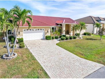 Exterior of property with tile driveway, landscaping, and red tile roof at 3818 Bordeaux Dr, Punta Gorda, FL 33950