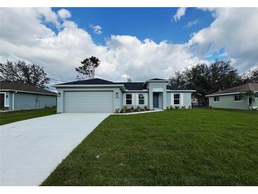 Charming single-story home with a well-manicured lawn and a two car garage at 6356 Opa Locka Ln, North Port, FL 34291