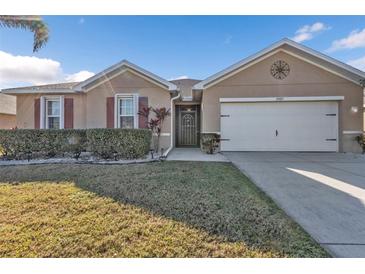 One-story home with attached garage, landscaped lawn, and a neutral color palette at 25017 Lalique Pl, Punta Gorda, FL 33950