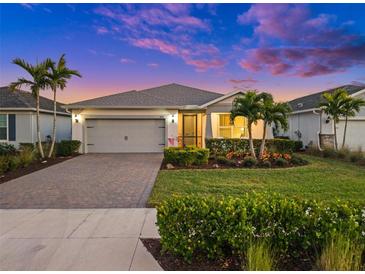 Attractive single-story home with a gray garage door and landscaped yard at 42154 Journey Dr, Punta Gorda, FL 33982