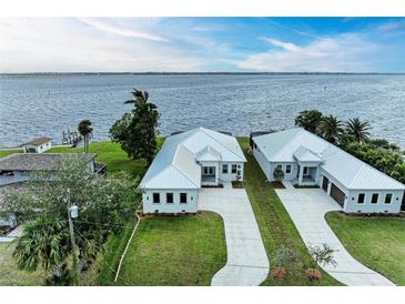 Two modern waterfront homes with metal roofs and attached garages at 112 Northshore Ter, Punta Gorda, FL 33980