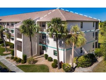 Two-story condo building with palm trees and a landscaped lawn at 175 Kings Hwy # 738, Punta Gorda, FL 33983