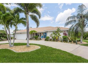 Single-story home with palm trees, circular driveway, and landscaped lawn at 195 Bayshore Ct, Punta Gorda, FL 33950