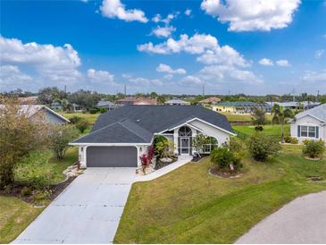 Aerial view of a single-story house with a gray roof and a two-car garage at 27072 Ecuador Dr, Punta Gorda, FL 33983