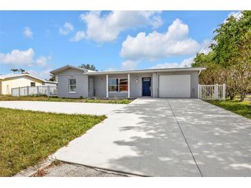 Newly renovated home with gray exterior, white columns, and a large driveway at 3112 Magnolia Way, Punta Gorda, FL 33950