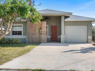 One-story house with attached garage and landscaped yard at 81 Michigan Ave, Englewood, FL 34223