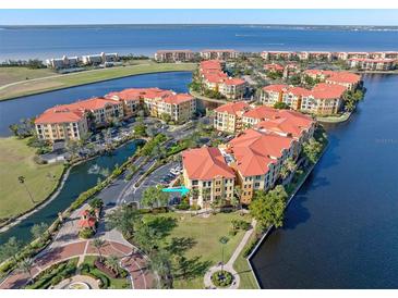 Aerial view of waterfront community with resort-style pool and tennis courts at 98 Vivante Blvd # 98317, Punta Gorda, FL 33950