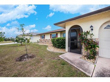 House exterior featuring a landscaped yard and screened entryway at 109 Peckham Se St, Port Charlotte, FL 33952