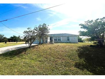 Single-story home with a large front yard and driveway at 12143 & 12151 Dubarry Ave, Port Charlotte, FL 33981