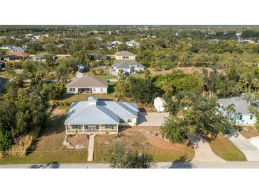 Aerial view of a single-Gathering home with a large backyard and surrounding neighborhood at 13204 Kakapo Ave, Port Charlotte, FL 33981