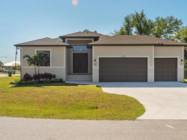 Single-story home with three-car garage, landscaping, and a neutral color palette at 13707 Begonia Cir, Port Charlotte, FL 33981