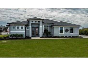 Gray house with a modern design, landscaping, and walkway at 15308 Acorn Cir, Port Charlotte, FL 33981