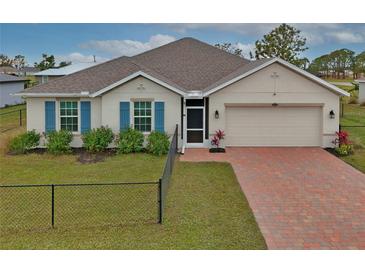 Single-story home with a brick driveway and landscaped front yard at 16039 Quinta Dr, Punta Gorda, FL 33955