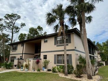 Exterior view of condo building with landscaping and palm trees at 19505 Quesada Ave # Rr203, Port Charlotte, FL 33948