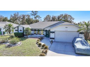 Single-story home with a landscaped yard, driveway, and attached garage at 21241 Winside Ave, Port Charlotte, FL 33952